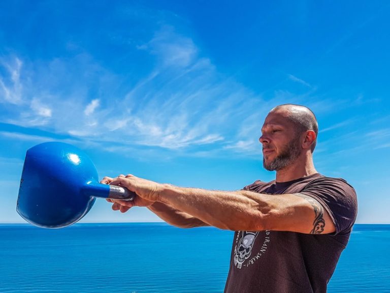 Man doing Kettlebell Swings gym workout to lose weight as a beginner